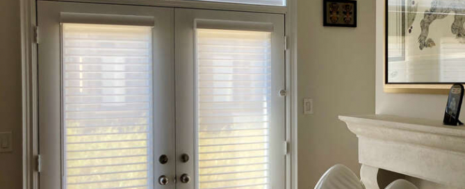 Custom light-filtering blinds on French doors in a stylish Toronto living room by Nifty Blinds.